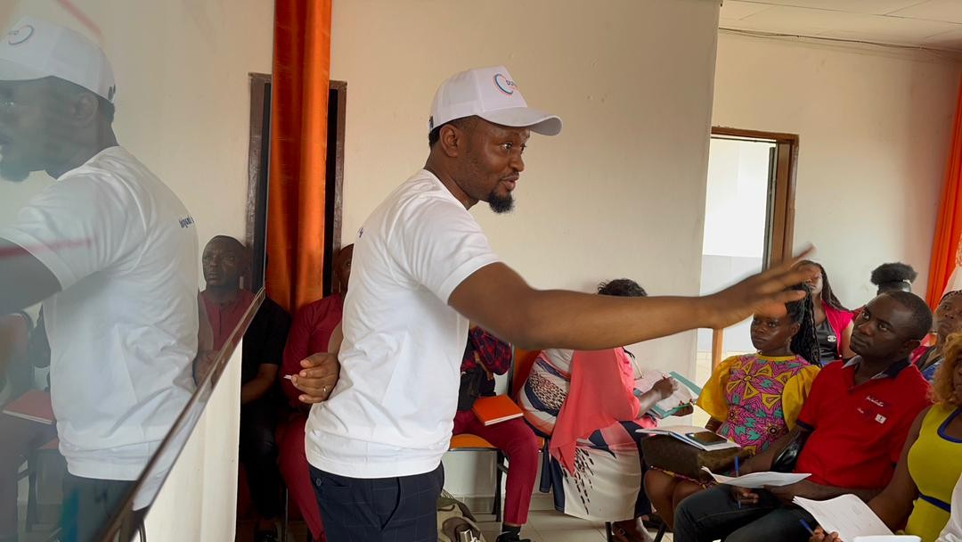 ENGEN Cameroons collaborate on an activity around a table while laughing.